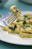 Herb gnocchi with sage butter on plate and fork