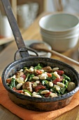 Pan-cooked sausage, bean and spinach dish