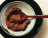 Red curry paste in a small bowl with spoon