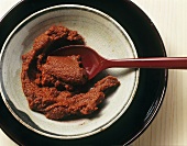 Rote Currypaste in einem Schälchen mit Löffel