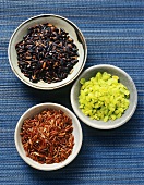 Red, green and black rice in small bowls