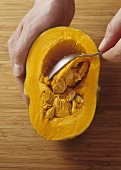 Hollowing out a pumpkin with a spoon