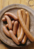 Several frankfurters on a wooden plate