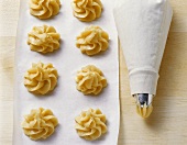 Choux pastry piped on to baking parchment for profiteroles