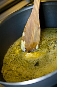 Butter melting in a frying pan with wooden spoon