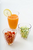 Tomato- and avocado salad in glasses with carrot juice