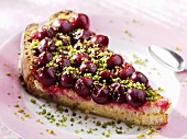 A piece of sour cherry tart with bread and pistachios