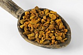 Turmeric root on a wooden spoon