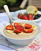 Cinnamon porridge with fresh strawberries & banana in bowl