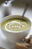 Erbsensuppe mit Pesto in einer Suppenschale mit Brot