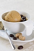 A scoop of coffee ice cream in a coffee cup with coffee beans