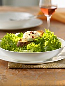 Toasted goat's cheese baguette on salad leaves