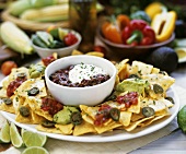 Chili con carne with tortilla chips, guacamole on a platter