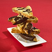 Anise biscotti with chocolate icing, stacked on a plate