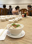 A bowl of congee in a restaurant (rice porridge, China)