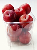 Red plums in a plastic punnet