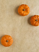 Three small orange pumpkins on paper