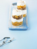 Layered dessert in glasses: pineapple, biscuits, soft cheese cream