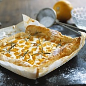 Quark and pumpkin tart with rosemary on baking parchment