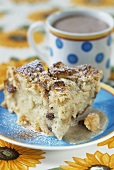 A piece of bread pudding with a cup of cocoa