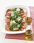 Beef carpaccio with rocket and Parmesan on a platter