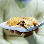 Woman holding spinach and mushroom pasties