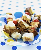 Cod and bread kebabs on a glass plate
