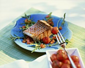 Grilled red snapper on tomato and rocket salad