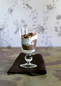 Chocolate ice cream with whipped cream, crumbs, raspberries in glass