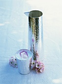 Silver jug and silver beaker of rose lassi with lemon juice