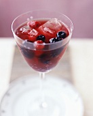 A glass of sangria with fresh berries