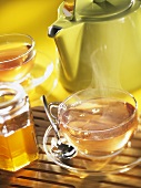 Cups of tea, teapot and honey