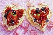 Two meringue hearts with lemon mascarpone cream and berries