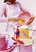Young woman baking (whisking eggs)