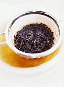 Rooibos tea in cup with tea strainer