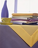 Tisch mit pastellfarbenem Geschirr und Tüchern