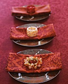Table laid in red with fabric napkins and rings