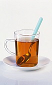 A glass of black tea with spoon