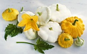 Yellow and white patty pan squashes with flower and leaves
