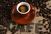 Cup of espresso, coffee beans on jute sack with the word 'Café'