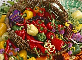 Assorted peppers in and beside a basket