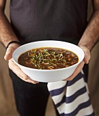 Man holding bowl of mince and pumpkin ragout