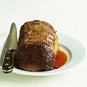 Roast beef on a plate with a knife