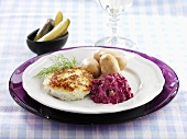A fish cake with red cabbage and potatoes