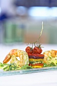 A tower of vegetables with fried king prawns and rocket