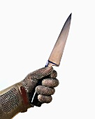 A hand in an oyster glove holding a sharp knife