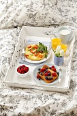 Frühstückstablett im Bett (French Toast, Omelett mit Kirschtomaten, Orangensaft, Milch)