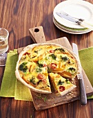 Vegetable tart with pumpkin and broccoli on a chopping board
