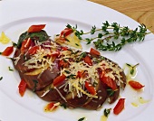 Aubergine fan with diced red pepper and Parmesan