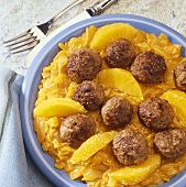 Meatballs with orange segments on curried onions